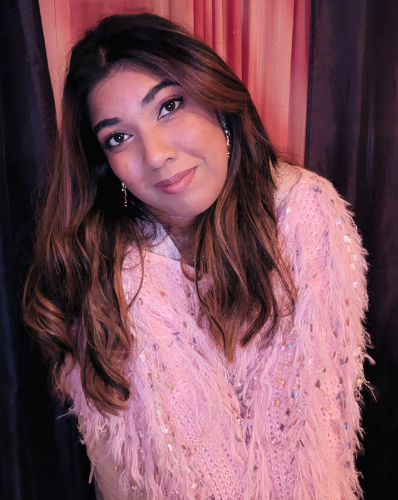 Nessy in pink, fuzzy sweater smiling